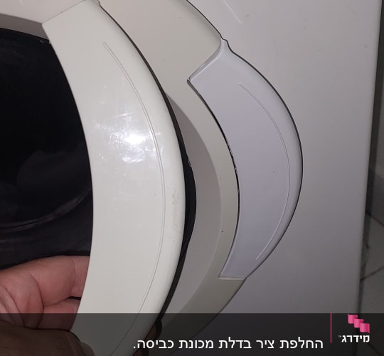 יד מחזיקה ידית של מכונת כביסה
